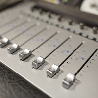 music, technology, electronics and equipment concept - mixing console at sound recording studio